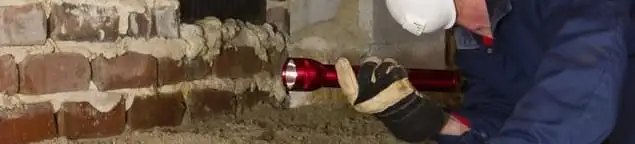 Pest control technician inspecting a crawl space for ant activity and entry points in Duluth, MN